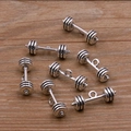 Sept pendentifs d'haltères en argent antique pour bijoux DIY sur un fond en bois - Style Haltère (20E16) / Argent antique