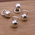 Detail of four silver kettlebell charm pendants on a textured wooden background - Kettlebell Style (20E06) / Antique Silver