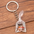 Transparent bag goldfish keychain with a silver key ring on a wooden texture background - Orange Goldfish Liquid Bag #12