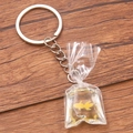 Creative resin goldfish water bag keychain with silver ring on dark wood background - Yellow Goldfish