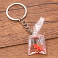 Creative resin goldfish water bag keychain with silver ring on wooden desk background - Red Goldfish