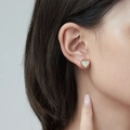 Elegant heart-shaped stud earrings in gold with white mother-of-pearl inlay worn by model - White Onyx Stud Earrings