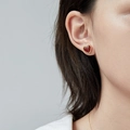 Minimalist red heart stud earrings with gold plating on a female model's ear - Red Agate Stud Earrings