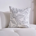 Modern square pillow case with black leaf patterns on a white fabric surface - White Leaves Black Border Cushion Cover