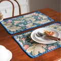Detailed macro view of vintage Jacquard floral placemat with blue pompom tassel fringe - Standard / Carnation with Blue Shell Edge