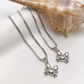 Polished silver crab pendant necklaces with box chains on white display props - Silver Tiny Crab Necklace (25110216)