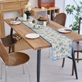 Camino de mesa floral con borde ondulado azul sobre mesa de madera decorativa - 30-120