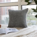 Square grey velvet throw pillow with decorative white pom-poms on a cozy window sill - Decorative Pillow Cover / Gray