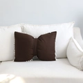 Cuscino carino a forma di fiocco marrone scuro a righe con pompon su divano bianco - caffè / 43x55cm
