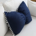 Cute dark blue bow-shaped cushion with white pom-pom trim on a cream-colored sofa - Decorative Pillow Cover / Navy Blue / 43x55cm