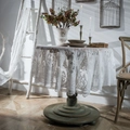 Elegante tovaglia rotonda in pizzo bianco con ricamo vintage su un tavolo di legno - Piccolo / Bianco