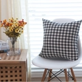 Federa per cuscino a quadretti bianchi e neri moderni posizionata su una sedia bianca elegante - 45x45 / Quadretti Piccoli Bianco e Nero