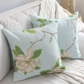 Coppia di federe azzurre quadrate con elegante stampa di magnolia su un divano bianco - 45x45 / Stile Orchidea Bianco Sporco