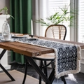 Modern black and white geometric table runner with tassel fringe on a dark wood table - Black Badge White Fringe / 30-120
