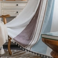 Μποέμ κουβέρτα patchwork με φούντες σε ξύλινη πολυθρόνα σε ένα ζεστό σπιτικό περιβάλλον - Ειδικό Μέγεθος 25τμ / Μπλε Καφέ Κεντημένες Ρίγες με Κρεμ Φούντες Θήκη για Κοντάρι