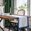 White linen table runner with dark blue floral lace edges on a rustic wooden table - Solid Linen Style