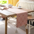 Nordic orange geometric jacquard table runner with tassels on a wooden dining table - Orange Greek Key