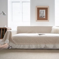Floral sofa cover with elegant white ruffled hem in a cozy warm living room setting - Embossed Daisy Ruffle