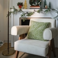 Green Christmas pillow cover with white leaf print on a cozy armchair by the fireplace - Green Maple Leaf