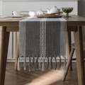 Camino de mesa nórdico a rayas grises con bordados y borlas sobre mesa de madera - 33x140 Camino de Mesa / Línea Única Gris + Borlas Hechas a Mano