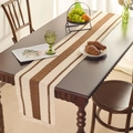 Camino de mesa de punto marrón y beige con rayas y borlas sobre mesa de comedor - Mantel individual / Caqui