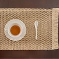 Beige woven table runner with tassels on a dark wood table with a white tea cup - Khaki Hollow Hemp Rope Fringe