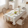 Detailed close-up of beige linen tablecloth with floral embroidery and tassel fringe edges - Pink Lily Style / 140x100CM