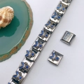 Detailed macro view of Italian charm bracelet with blue enamel flower and stainless steel stamp - Blue Enamel Floral Style (Model 109)