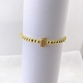 Detalle de pulsera de cuentas doradas con dije de letra E con micropavé sobre fondo blanco - Oro E