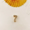 Number 7 golden pendant with white zircon pavé on a summer style shell background - Number 7