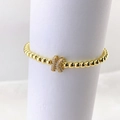Primer plano de pulsera de cuentas doradas con dije de mariposa brillante de circón - Oro K