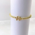 Primer plano de pulsera de cuentas doradas con colgante de letra M en micro pavé brillante - Oro M