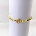 Primer plano de pulsera de cuentas doradas con un dije de letra O con micro pavé - Oro O