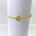 Detalle de pulsera elástica de cuentas doradas con dije de letra Q micro-engastado - Oro Q
