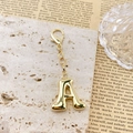 Detalle macro del llavero dorado letra A en 3D con un acabado de espejo brillante - Letra A