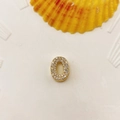 Golden letter O pendant with pavé set crystals on white decorative ceramic plate - Number 0