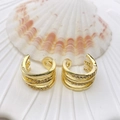 Drei-lagige goldene Ohrmanschette mit Mikro-Zirkonia auf weißem Muschelhintergrund - Dreilagiges Wickel-Design mit Strass, offener Stil (67 Modelle)
