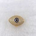 Macro view of golden evil eye charm with blue zircon stones on white plush fabric - Gold Multi-Color Evil Eye (Style 138)