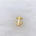 Détail d'un pendentif ancre doré poli sur un fond en peluche blanche douce et luxueuse - Style Ancre (258 Styles) / Or