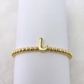 Makro-Detail des 18k vergoldeten Perlenarmbands mit einem blasenförmigen Buchstaben-L-Anhänger - L