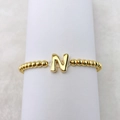 Detailansicht eines 18k vergoldeten elastischen Perlenarmbands mit glänzendem Buchstaben-N-Anhänger - Buchstabe N
