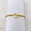 Detail eines 18k vergoldeten Perlenrings mit einem 3D-Buchstaben-Q auf weißem Halter - Buchstabe Q