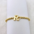 Detail eines 18k vergoldeten Perlenarmbands mit einem polierten 3D-Buchstaben R Anhänger - Buchstabe R