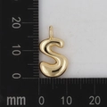 Goldener S-förmiger Buchstabenanhänger auf einem Lineal zur Darstellung der Größe - Buchstabe S