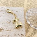 Porte-clés lettre Z doré avec fermoir mousqueton sur fond de pierre naturelle beige - Lettre Z