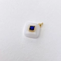 Macro shot of square pendant with blue gemstone inlay and golden metal frame detail - White Jade