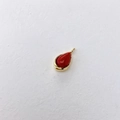 Detailed view of teardrop-shaped red gemstone pendant with polished gold bezel setting - Red Agate Teardrop