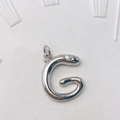 Anhänger aus poliertem Messing in Form des Buchstabens G mit einem kleinen funkelnden Stein - Silber G