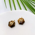 Macro detail of hexagonal tiger eye stone pendant with gold butterfly and zircon inlay - Tiger's Eye