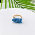 Macro detail of a fish-shaped turquoise ring with wire-wrapped gold band and rhinestone eye - Sodalite Look (Style J)